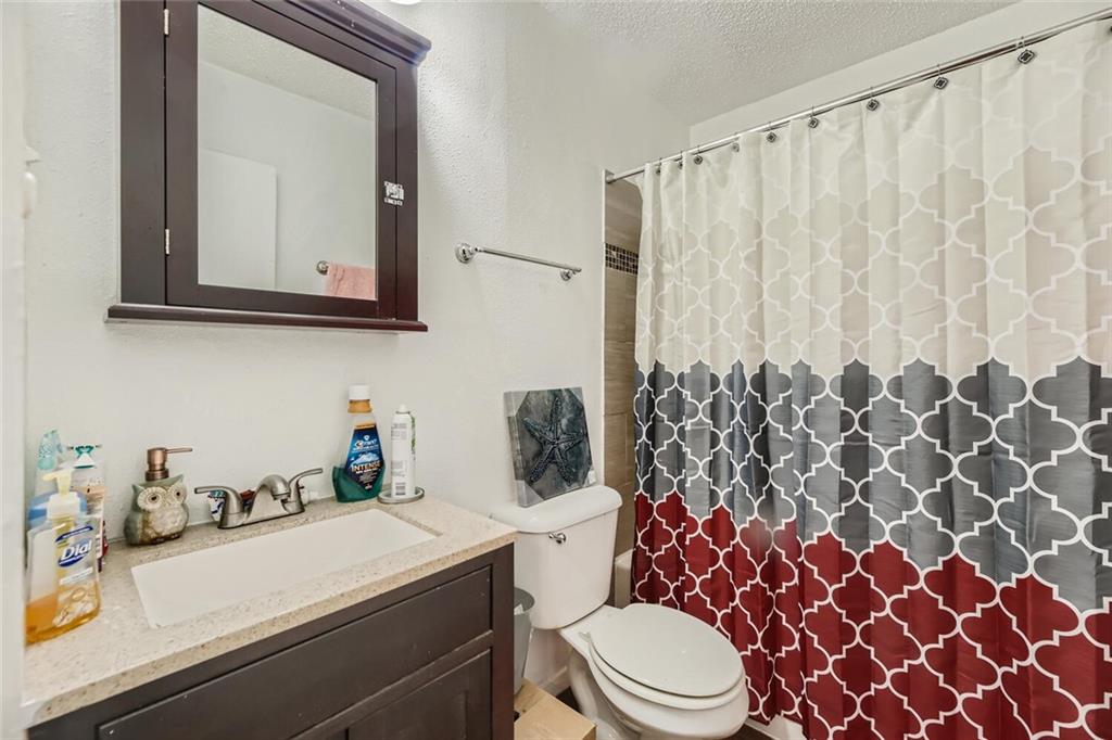 2401 Manor Road, Unit 111 Austin, TX 78722 - Photo 16 of 23 a bathroom with a sink a toilet and shower curtain