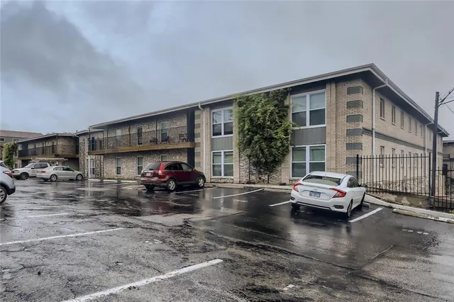 a view of a cars park in front of a building