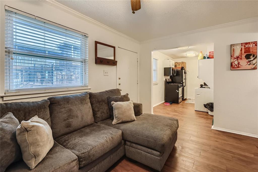 2401 Manor Road, Unit 111 Austin, TX 78722 - Photo 2 of 23 a living room with furniture and a flat screen tv