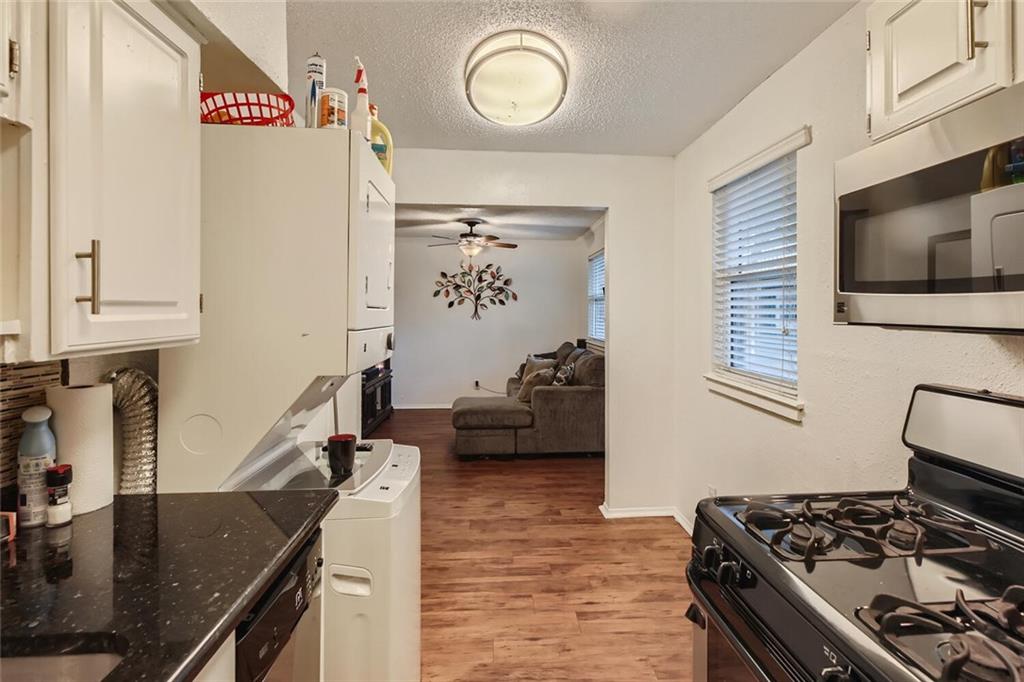 2401 Manor Road, Unit 111 Austin, TX 78722 - Photo 5 of 23 a kitchen with stainless steel appliances granite countertop a sink stove and refrigerator