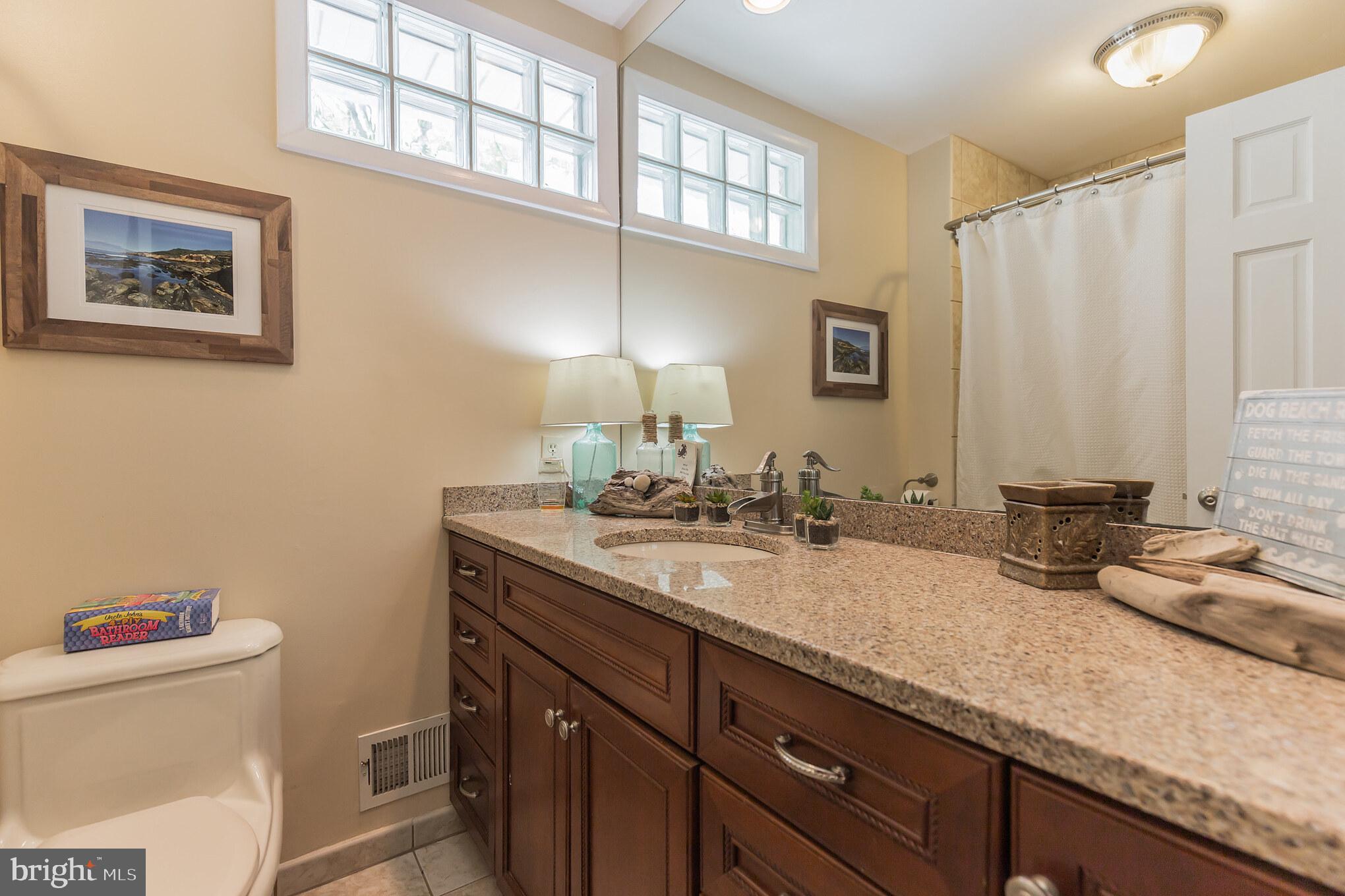 7020 Hadlow Drive Springfield, VA 22152 - Photo 16 of 29 a bathroom with a granite countertop sink a toilet and a large mirror