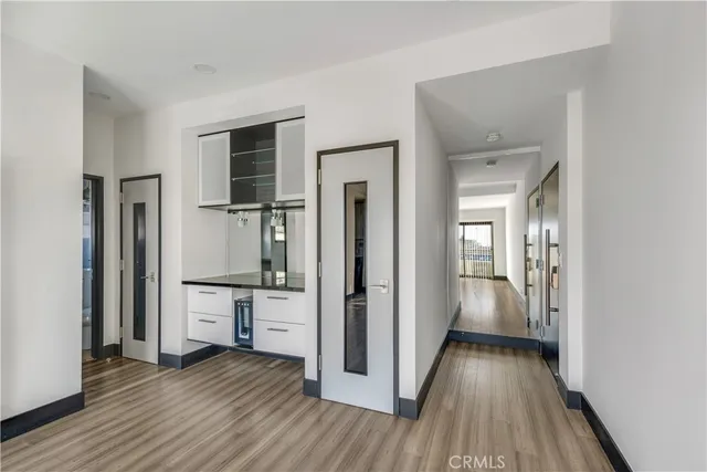 a view of a hallway with wooden floor and closet