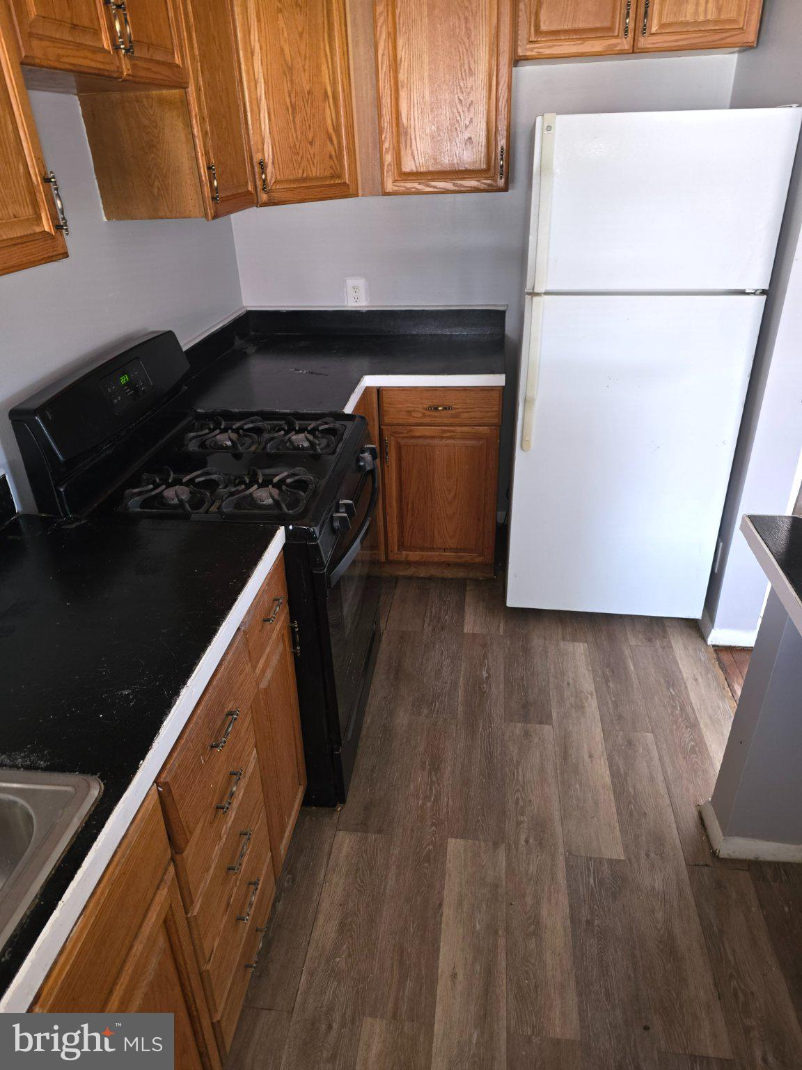 4404 Mountview Road Baltimore, MD 21229 - Photo 5 of 22 a kitchen with wooden cabinets and a stove top oven