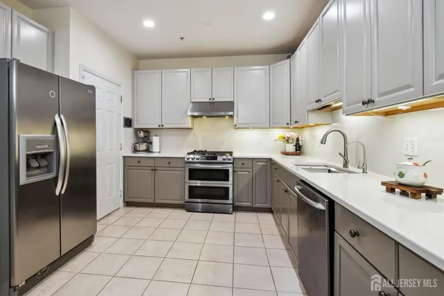 a kitchen with stainless steel appliances granite countertop a sink stove oven and refrigerator