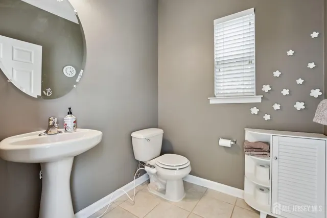 a bathroom with a sink toilet and a mirror