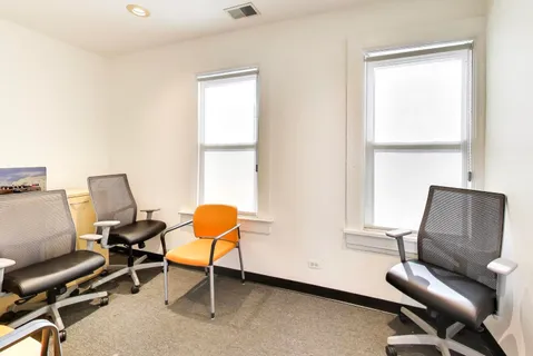 a view of a workspace with furniture and a window