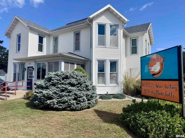a view of a white house with large windows and a flower garden