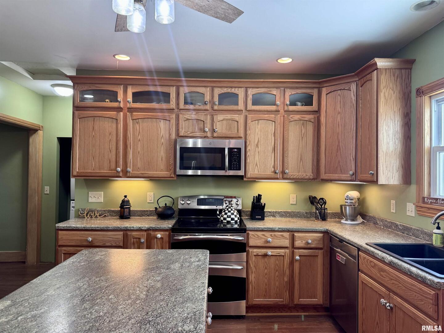 1415 4th Street Fulton, IL 61252 - Photo 37 of 58 a kitchen with stainless steel appliances granite countertop a stove a sink dishwasher and a microwave oven with white cabinets