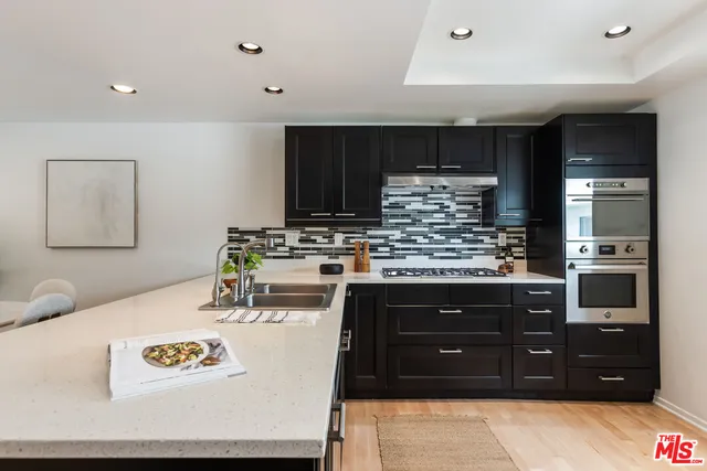 a large kitchen with stainless steel appliances and large cabinets