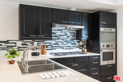 a kitchen with kitchen island a counter top space a sink and refrigerator