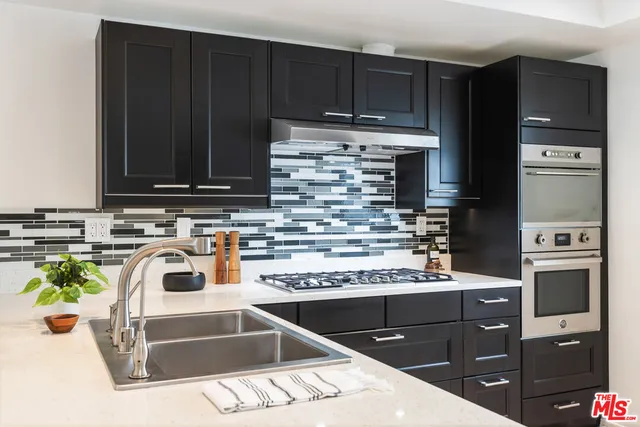 a kitchen with kitchen island a counter top space a sink and refrigerator