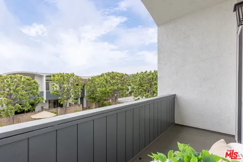 a bedroom with a bed table flowerpot and window