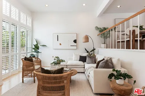 a kitchen with kitchen island granite countertop a table chairs sink and cabinets