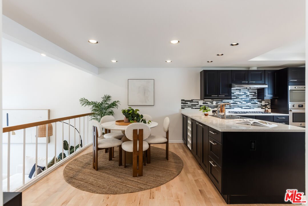13230 Fiji Way, Unit B Marina del Rey, CA 90292 - Photo 9 of 65 a kitchen with kitchen island granite countertop a table chairs sink and cabinets