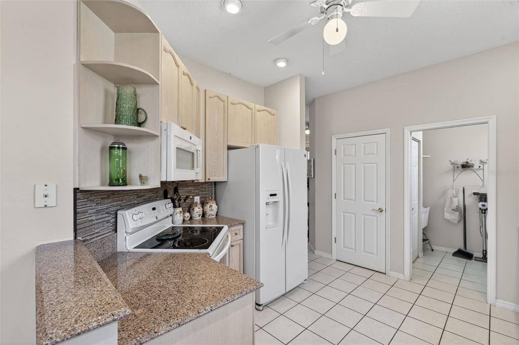 4266 Summertree Road Venice, FL 34293 - Photo 16 of 64 a kitchen with stainless steel appliances granite countertop a sink a stove and a refrigerator