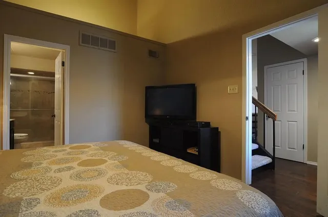 a bedroom with a bed and a flat screen tv