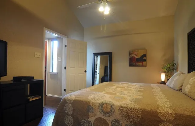 a bedroom with a bed and dresser with mirror