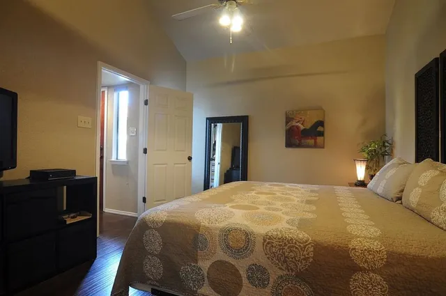 a bedroom with a bed and dresser with mirror