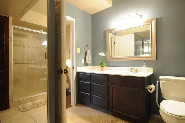 a bathroom with a sink vanity mirror and toilet
