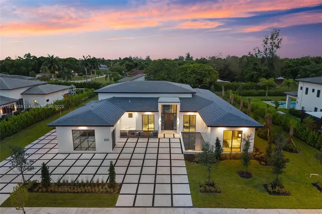 an aerial view of a house with a garden and lake view