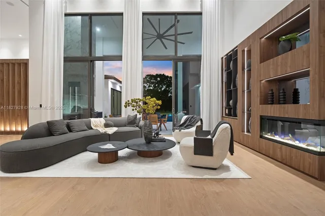 a living room with fireplace furniture and a large window