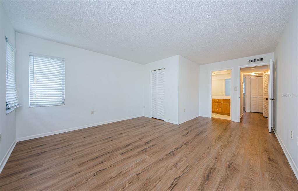 2650 Countryside Boulevard, Unit F110 Clearwater, FL 33761 - Photo 11 of 26 a view of empty room with wooden floor and fan