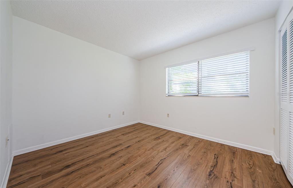 2650 Countryside Boulevard, Unit F110 Clearwater, FL 33761 - Photo 15 of 26 an empty room with wooden floor and windows
