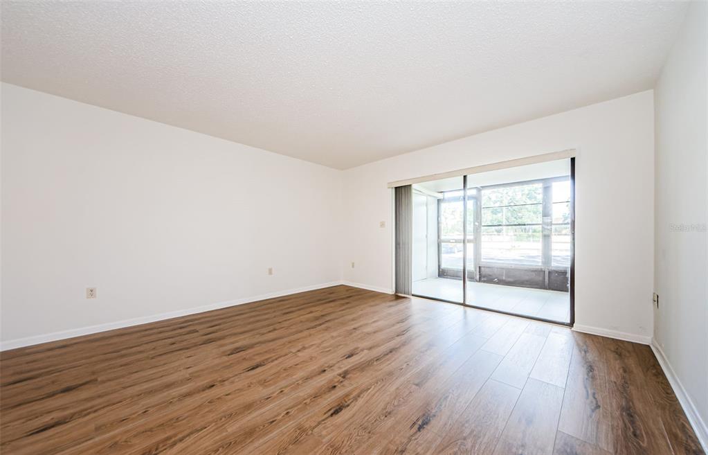 2650 Countryside Boulevard, Unit F110 Clearwater, FL 33761 - Photo 8 of 26 an empty room with wooden floor and windows
