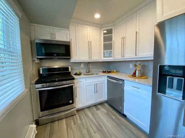 a kitchen with stainless steel appliances granite countertop a stove a sink and a microwave