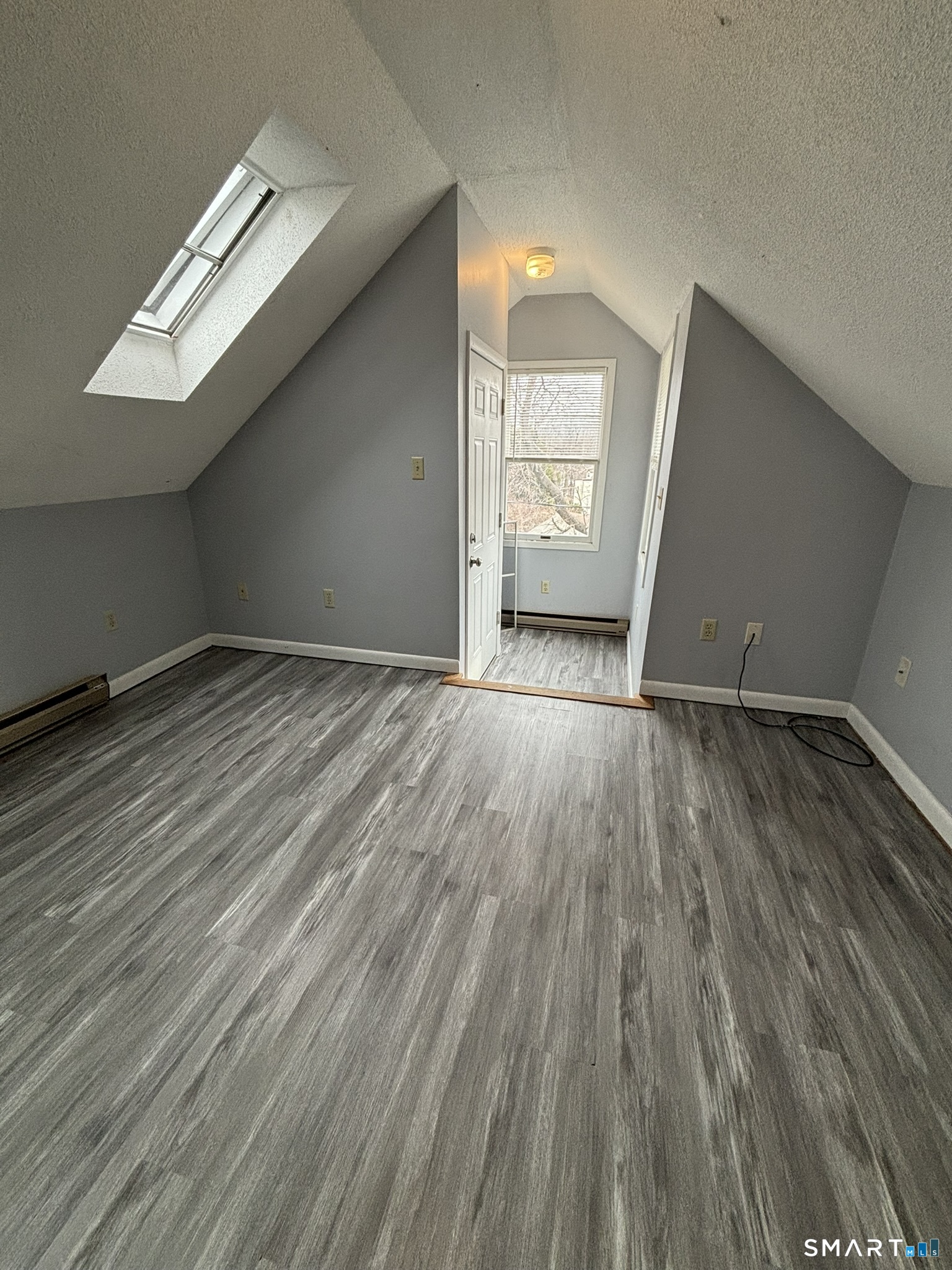 11 Roberts Street, Unit 3 Bristol, CT 06010 - Photo 5 of 11 a view of an empty room with wooden floor and a window