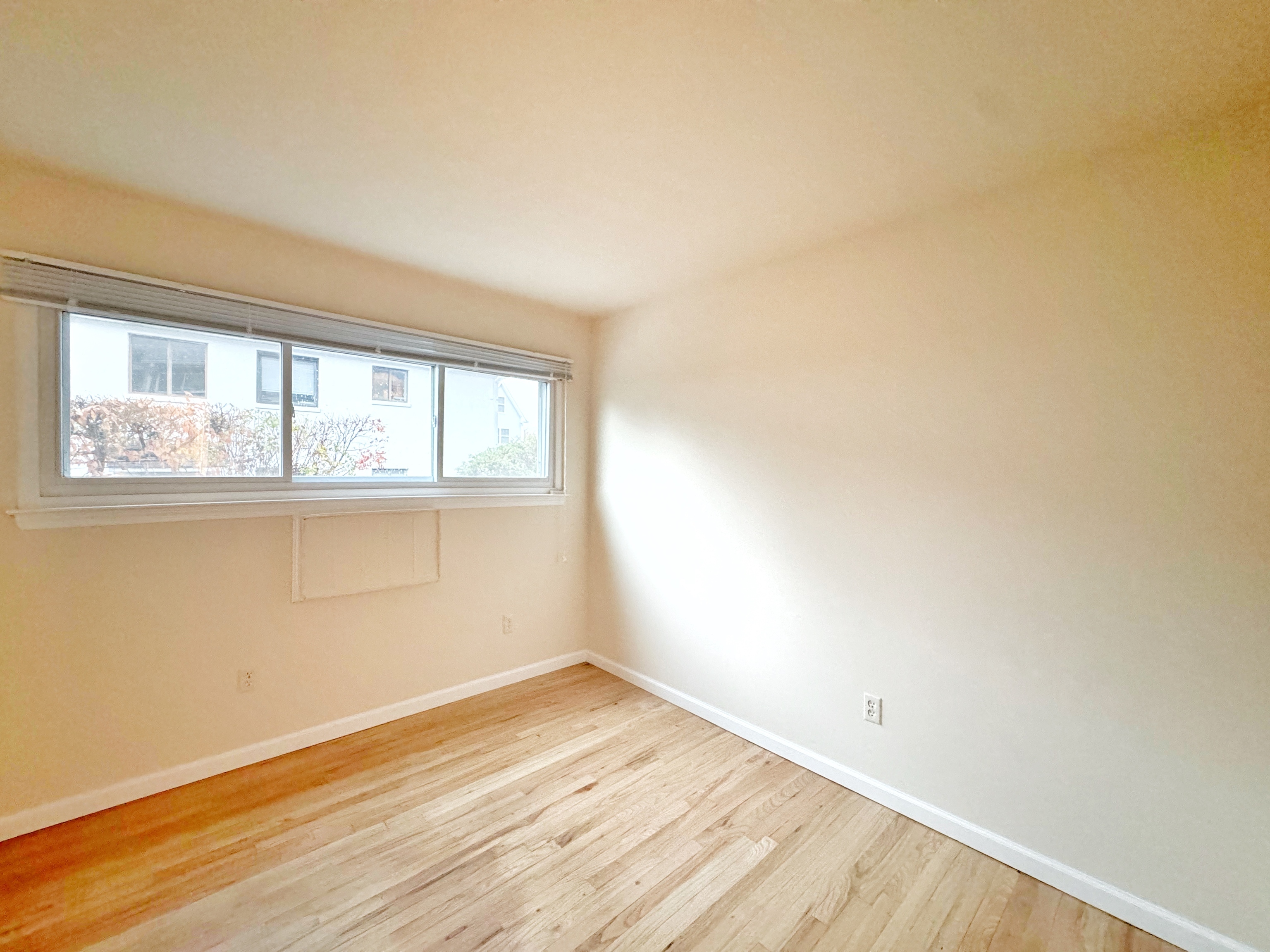 24 Ferris Avenue, Unit 4 Norwalk, CT 06854 - Photo 11 of 12 an empty room with wooden floor and windows