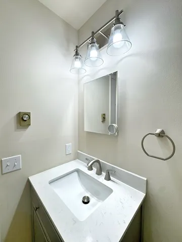 a bathroom with a sink vanity and a mirror
