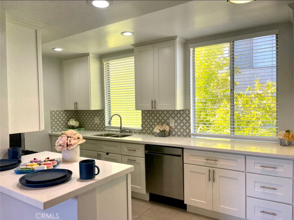 a kitchen with sink a window and cabinets