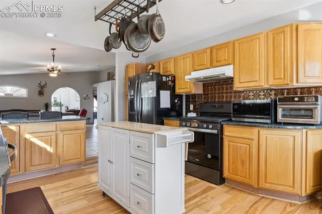 a kitchen with stainless steel appliances granite countertop a stove a sink and dishwasher with white cabinets