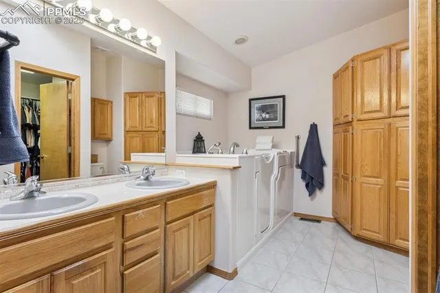 a en suite bathroom with a double vanity sink a mirror and a shower