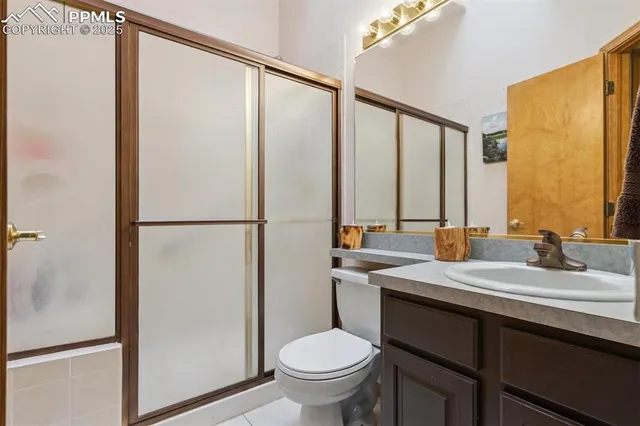 a bathroom with a granite countertop sink toilet and mirror
