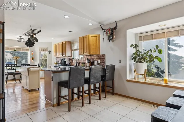 a dining hall with stainless steel appliances a dining table and chairs with garden view