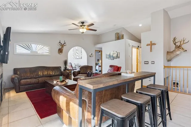 a living room with furniture a chandelier and a dining table