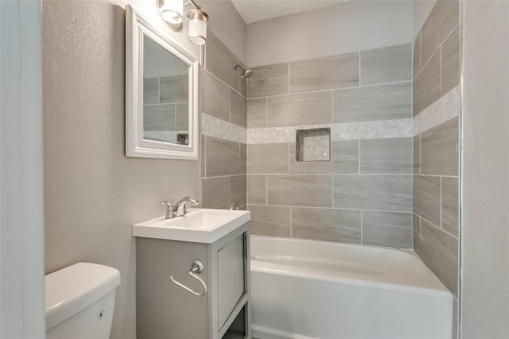 507 Enid Street, Unit B Houston, TX 77009 - Photo 6 of 8 A single bath with large tiles and newer vanity.
