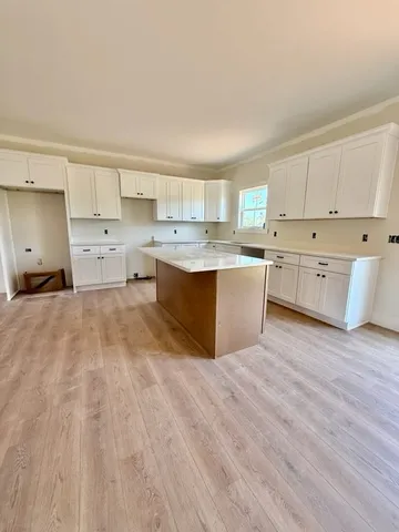 a kitchen with cabinets wooden floor and stainless steel appliances