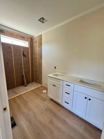 a view of an empty room with cabinet and mirrors