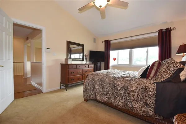 a bedroom with a bed dresser and a large window