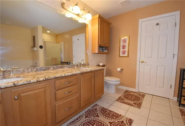 a bathroom with a granite countertop sink toilet and shower
