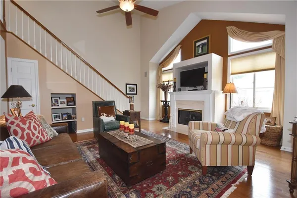 a living room with furniture a flat screen tv and a fireplace