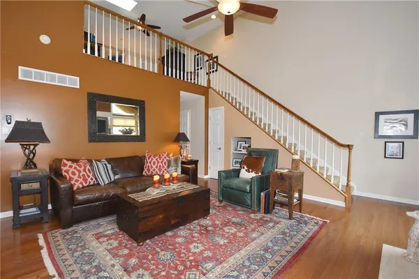 a living room with furniture stairs and a rug