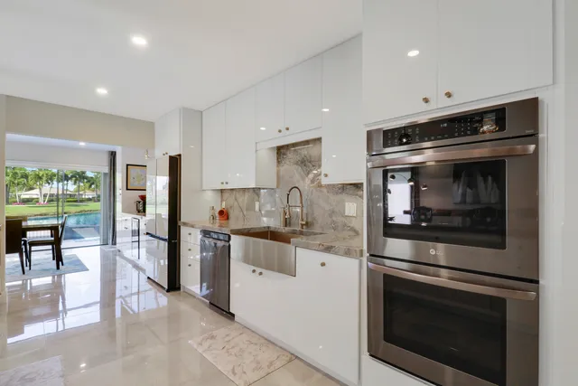 a living room with furniture kitchen view and a large window