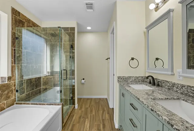 a bathroom with a granite countertop sink mirror bathtub and shower