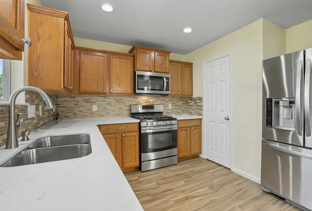 a kitchen with granite countertop a refrigerator and a sink