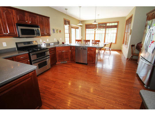 7904 Cunningham Road Rockford, IL 61102 - Photo 3 of 11 a kitchen with stainless steel appliances a stove a sink a microwave a dining table and chairs
