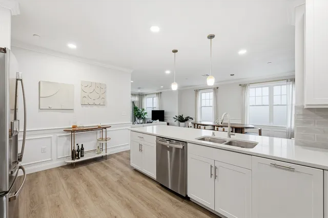 a kitchen with white cabinets and sink